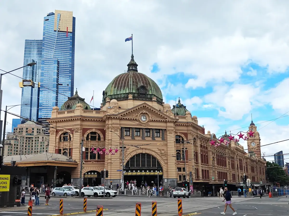 Flinders Street Station with its central dome, clocks and Melbourne high-rise buildings behind it.