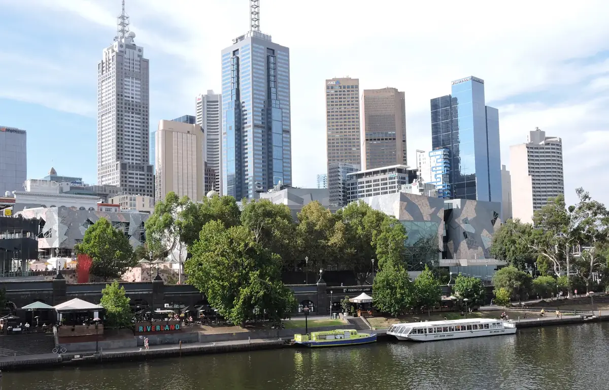 Daytime view across the Yarra River toward Federation Square and the Melbourne CBD skyline.